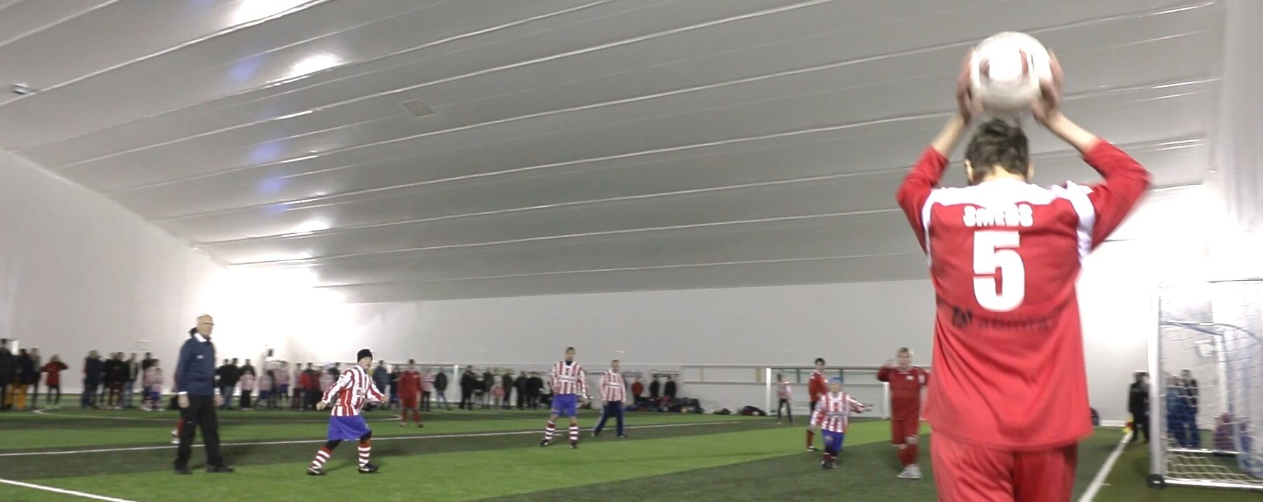Kids playing indoor football with sports canopy roof